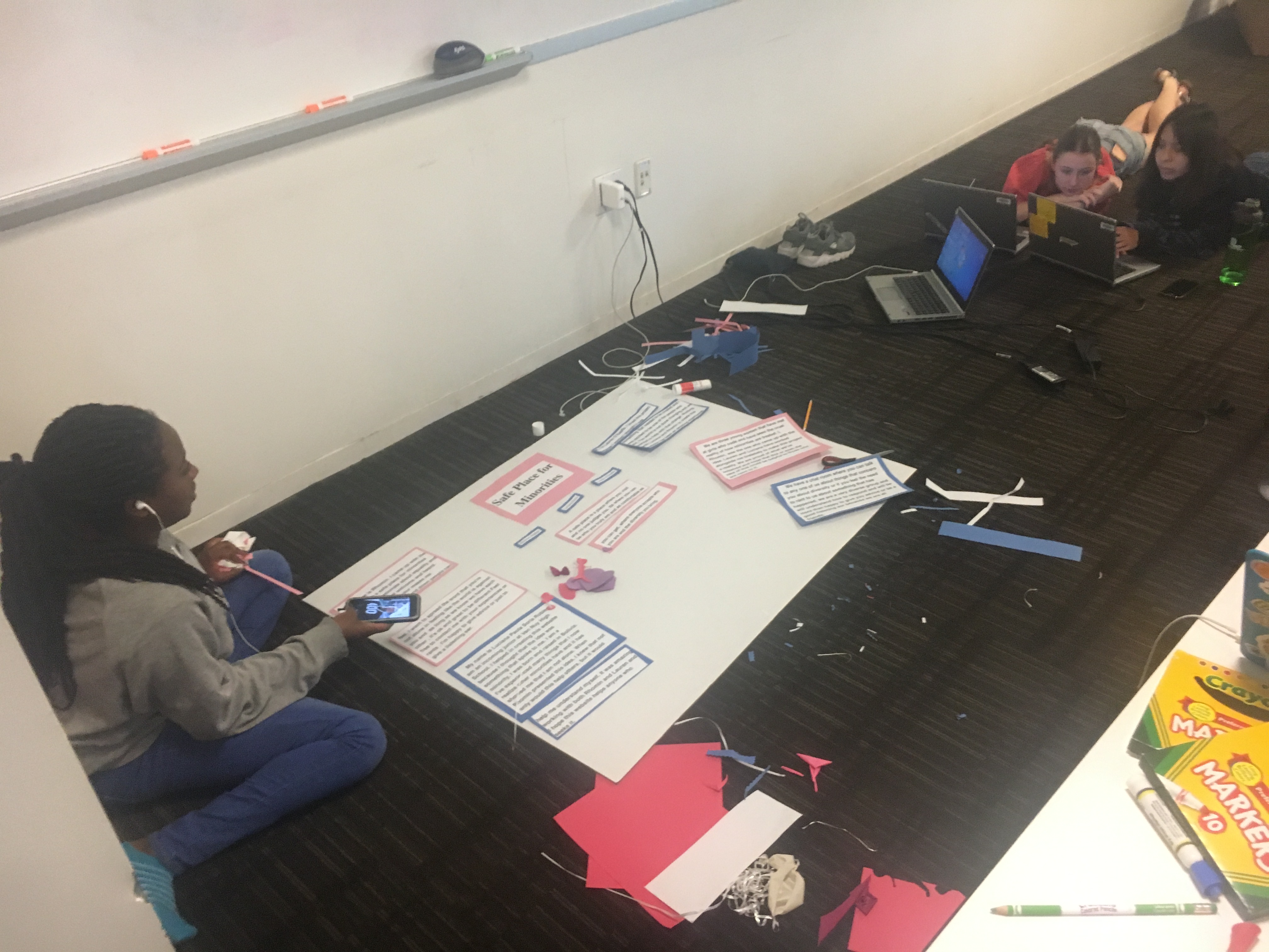 Students in the "Safe Place for Minorities" group working on their poster board