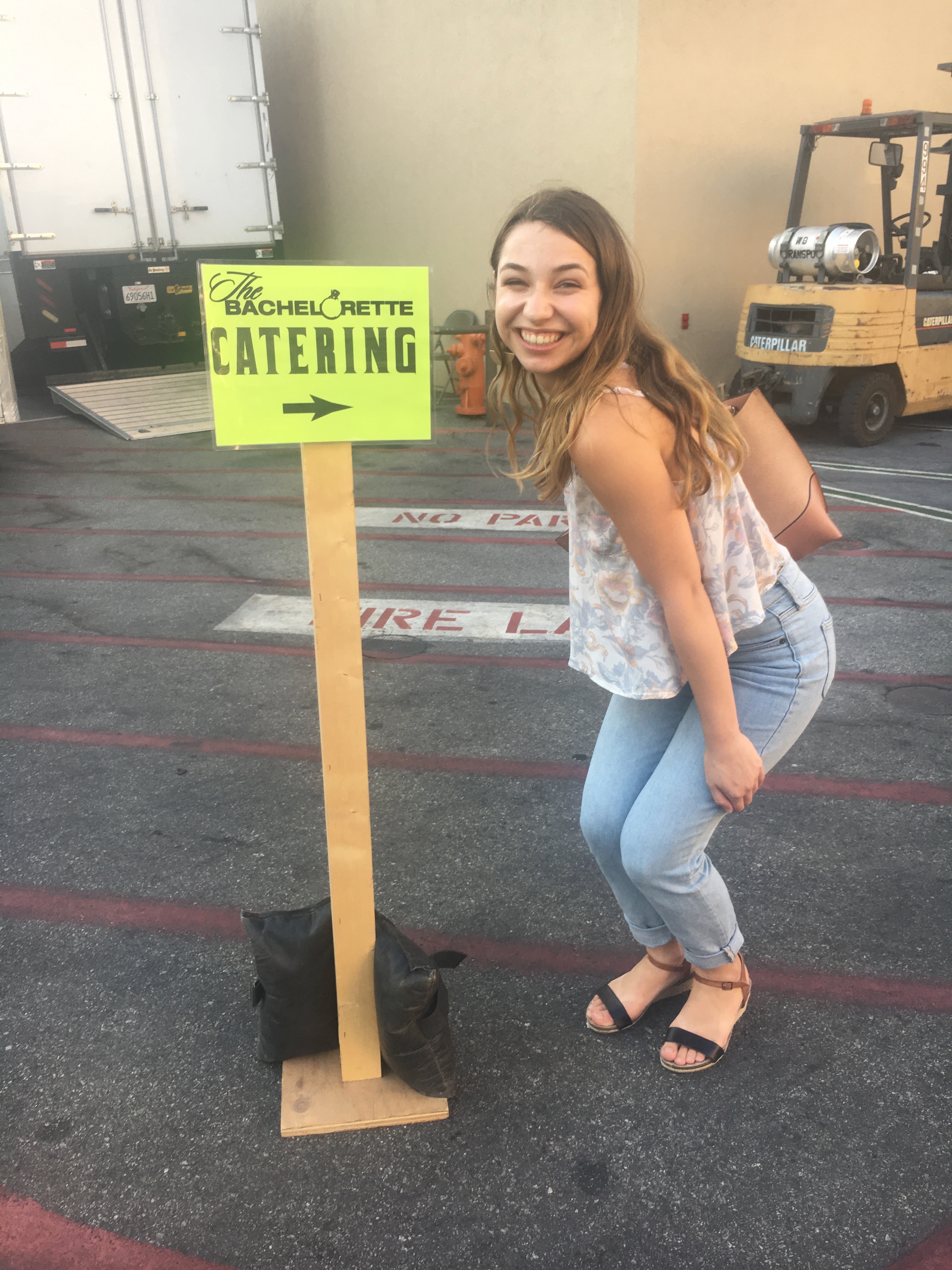 Sammy in front of a Bachelorette Catering sign on the Warner Bros. lot